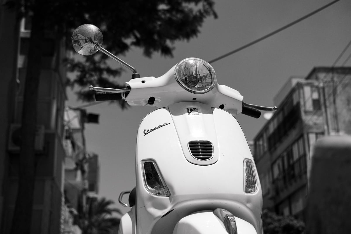 Grayscale Photo of a Vespa Scooter